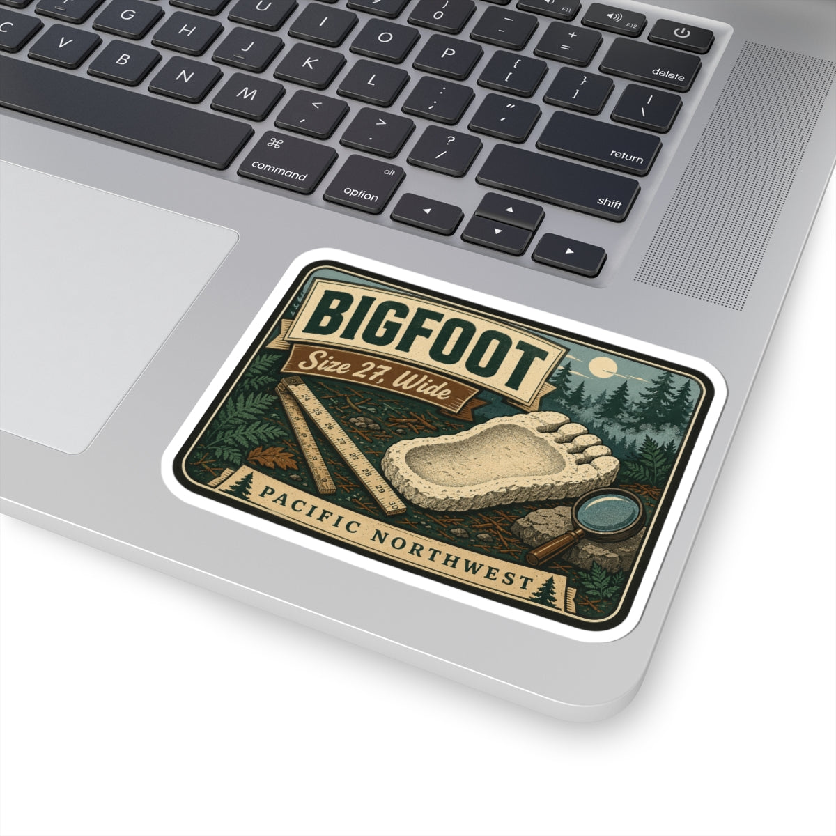 Bigfoot footprint sticker with Size 27, Wide label, pine trees, ruler and magnifying glass