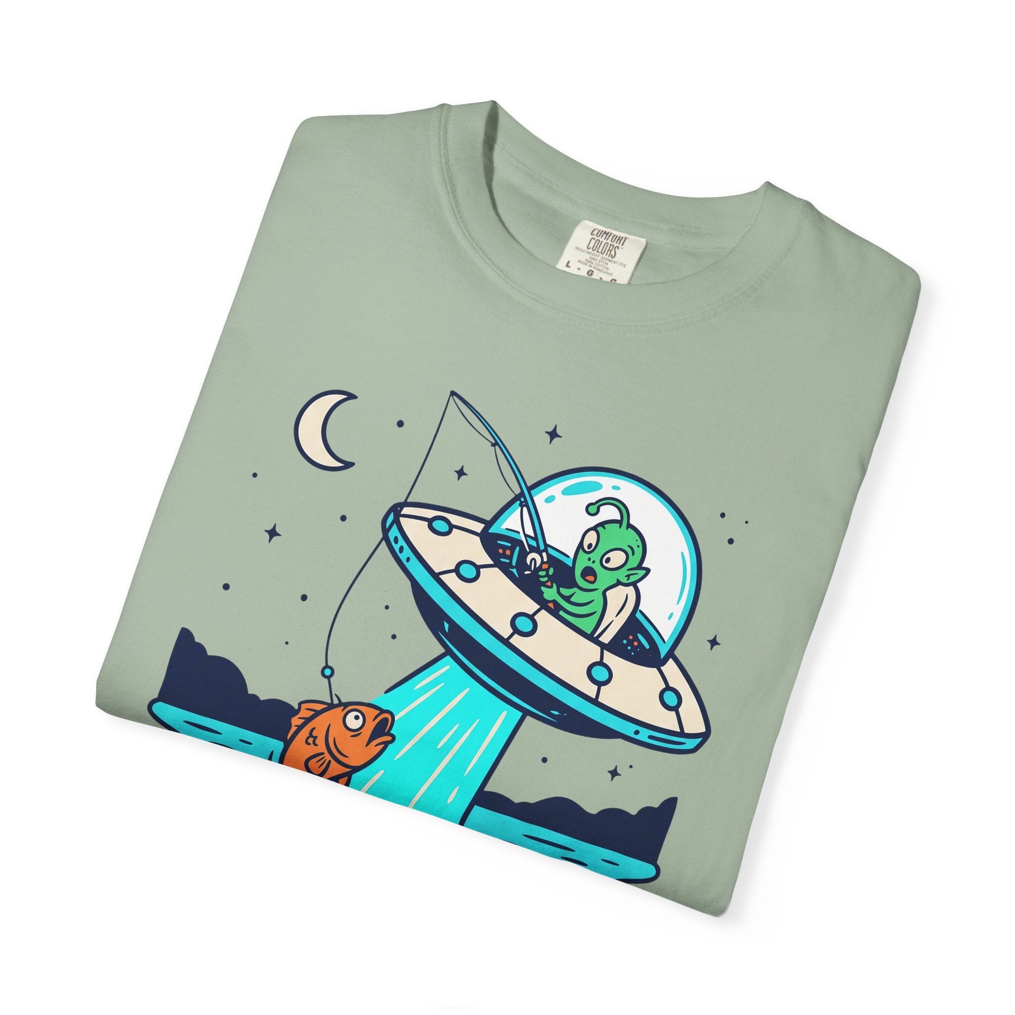Sage green T-shirt with alien fishing UFO graphic and stars on the front.