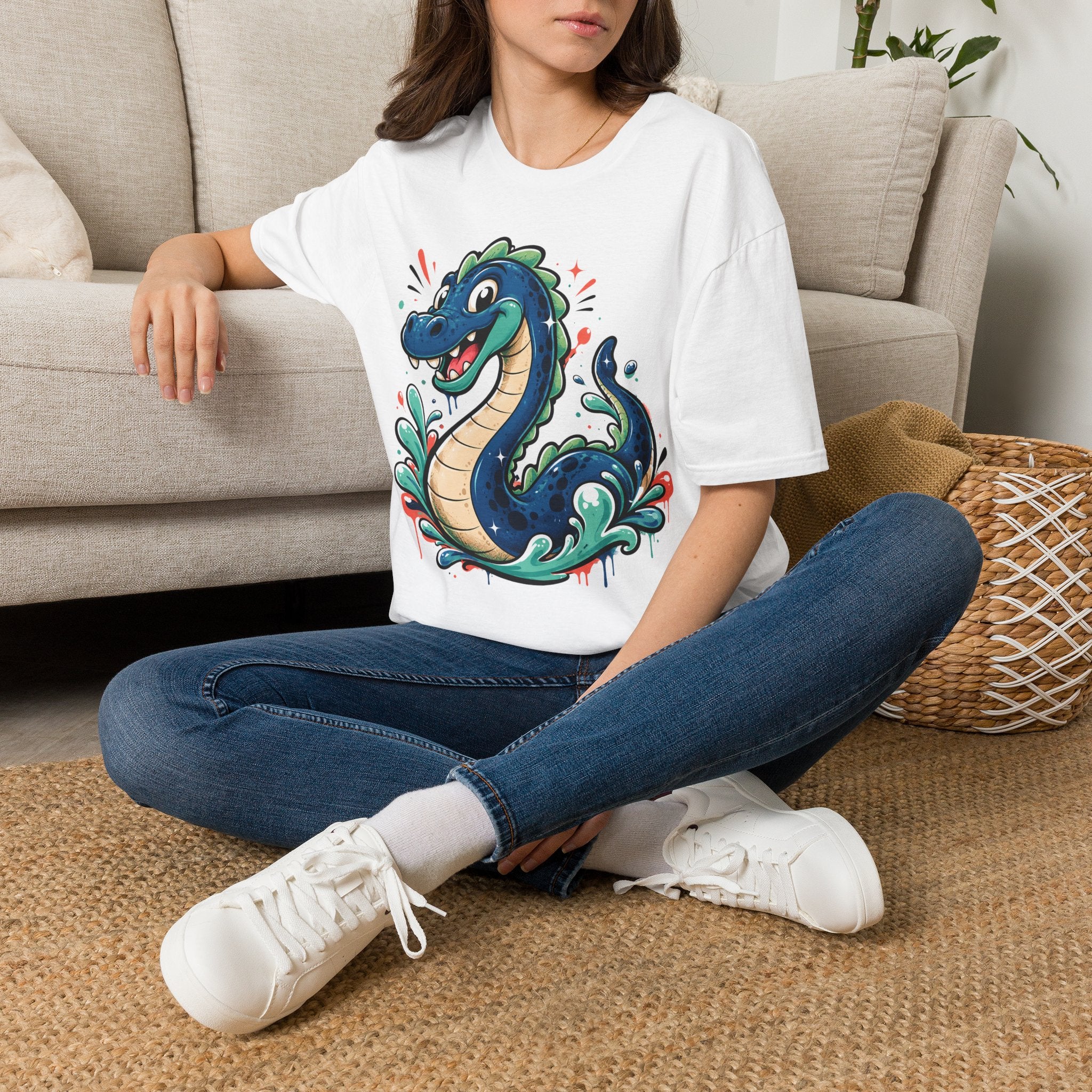 White sea serpent graphic T-shirt featuring a smiling cartoon lake monster front print
