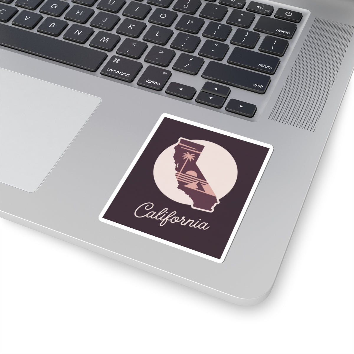 California sticker on a laptop keyboard, mauve state silhouette with “California” script