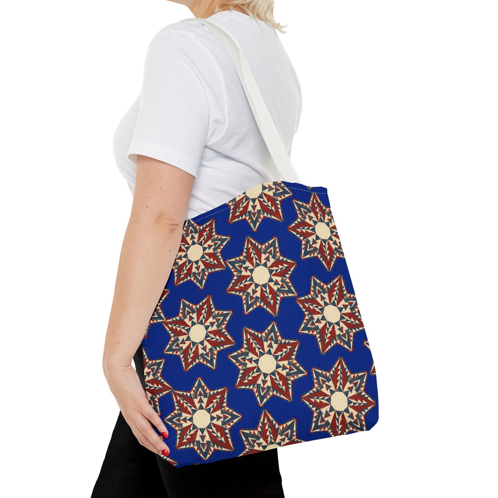 Blue starburst floral tote bag with white handles, shown on a person from the side