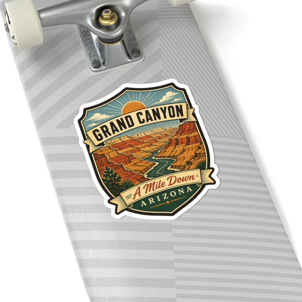 Shield-shaped travel sticker featuring canyon scenery, “GRAND CANYON,” “A Mile Down,” “ARIZONA.”