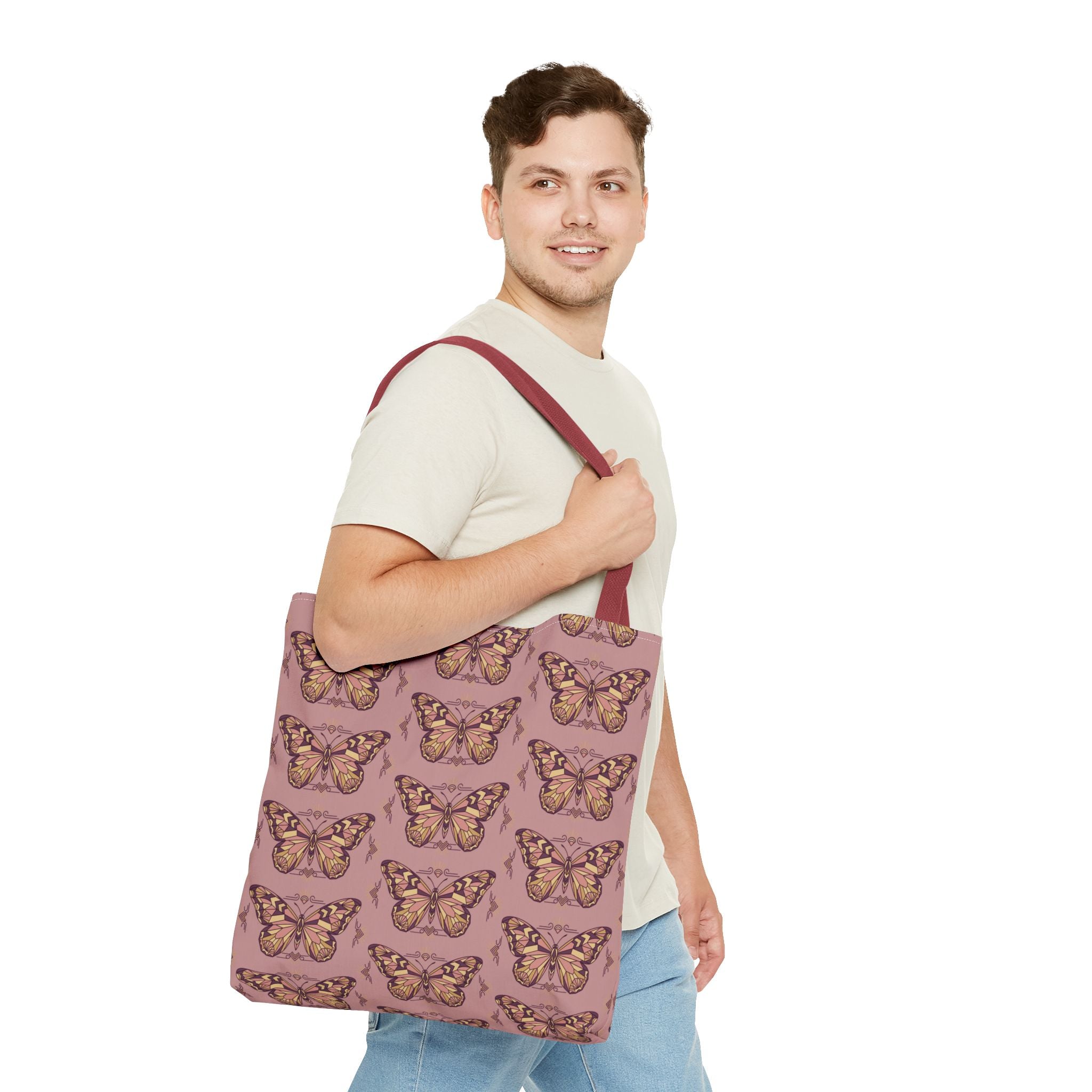 Butterfly-pattern tote bag in pink with brown-red straps, held across chest