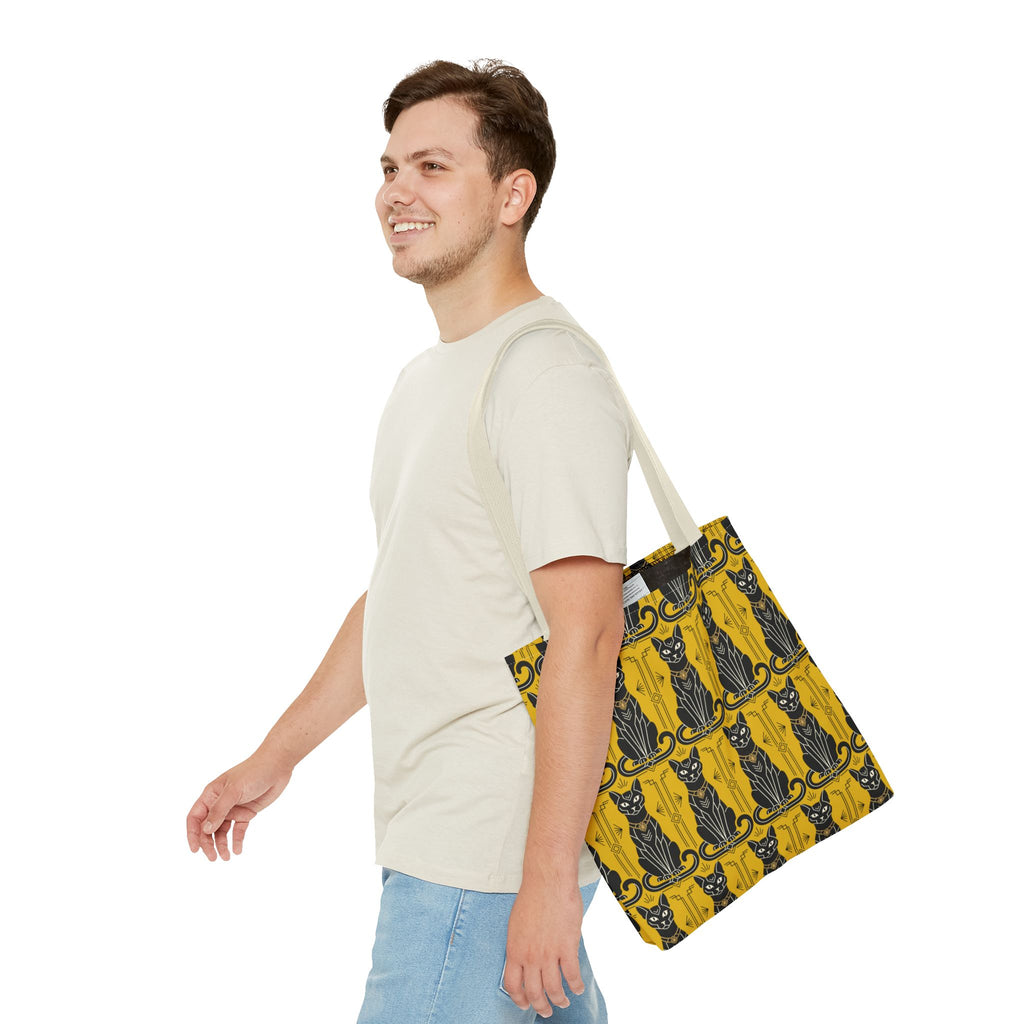 Yellow cat-pattern tote bag carried at side with navy cat print and light beige straps