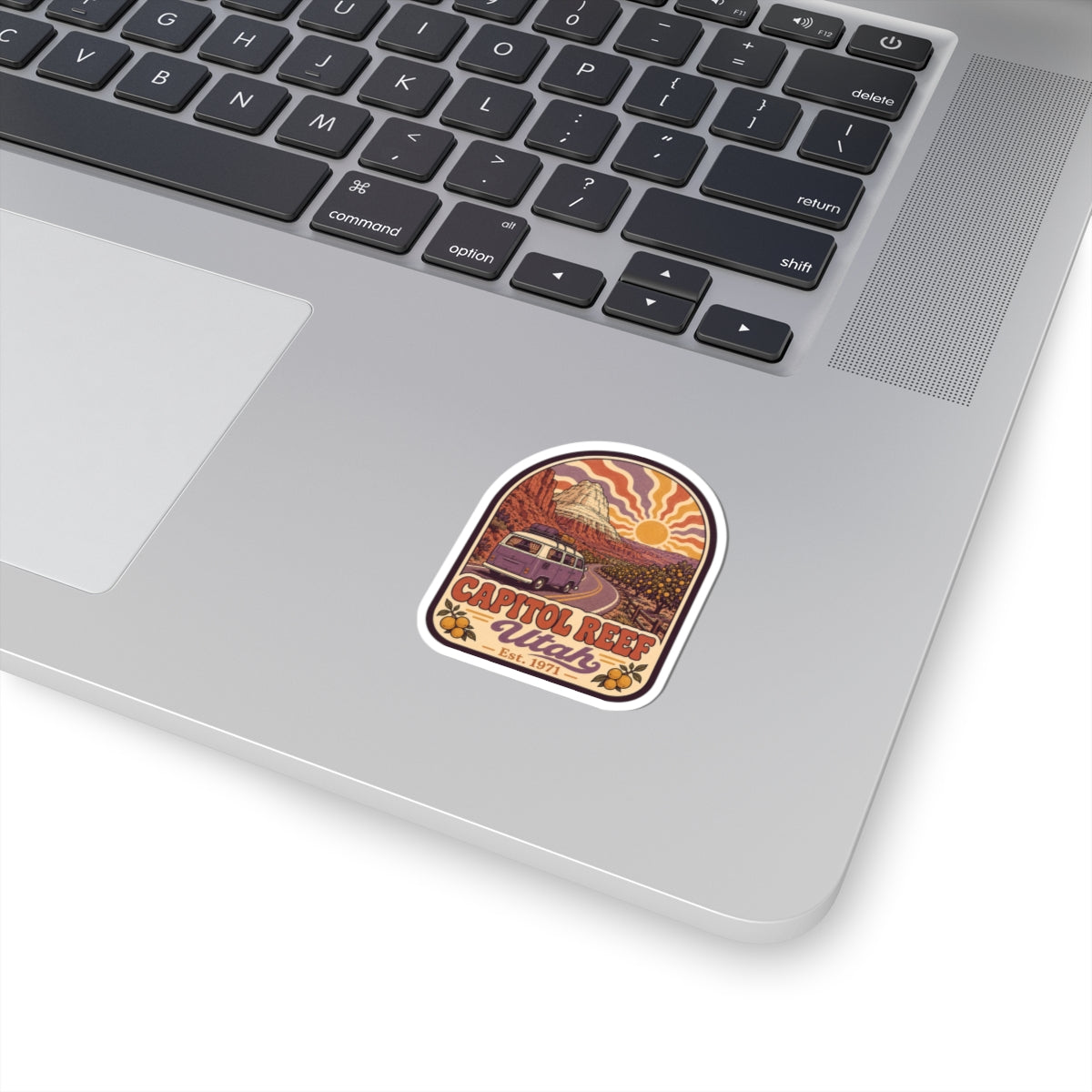 Rounded kiss-cut sticker with desert landscape, camper van, and desert sun icon