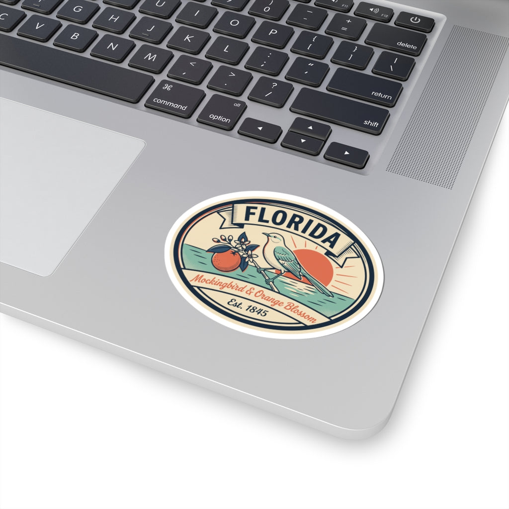 Florida round sticker applied to a laptop, featuring mockingbird and orange blossom badge