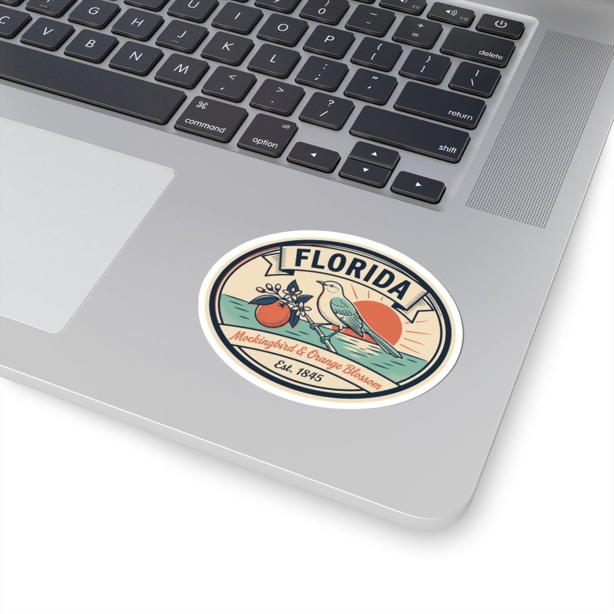 Florida round sticker applied to a laptop, featuring mockingbird and orange blossom badge