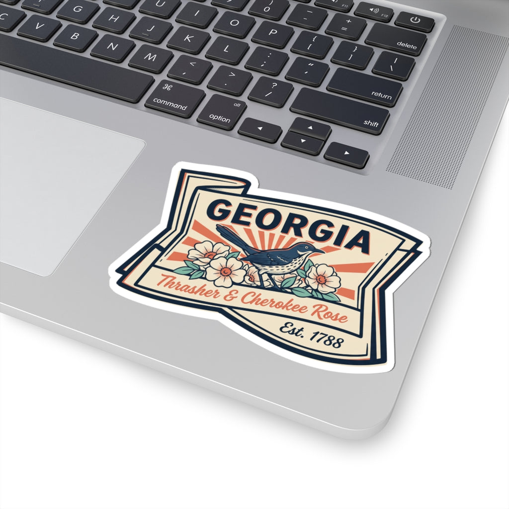 Georgia state badge sticker on laptop lid, blue bird and flowers with Est. 1788