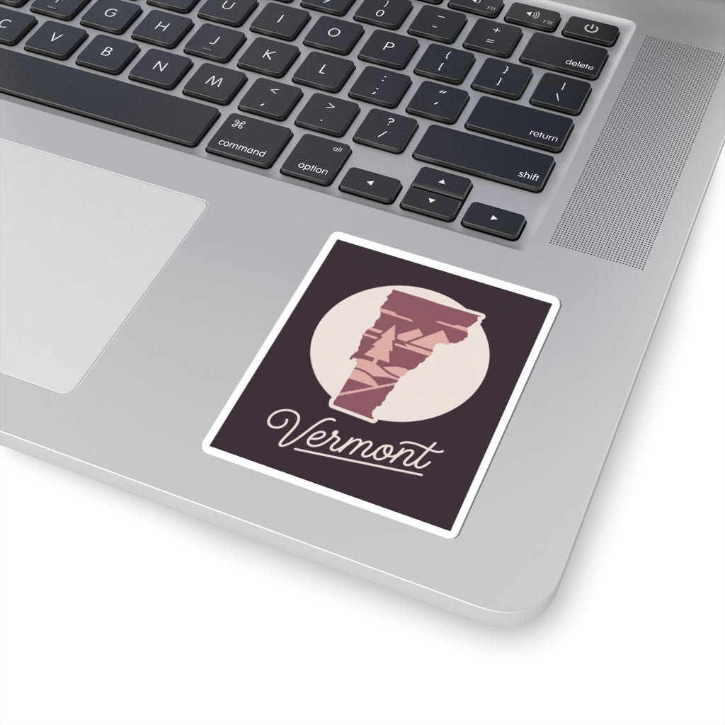 Vermont state silhouette sticker with maroon pine scene and cursive 'Vermont' on a dark label
