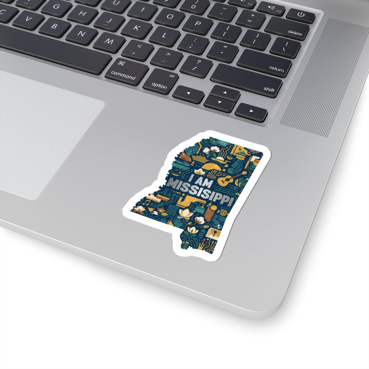 “I AM MISSISSIPPI” sticker on laptop, dark blue circuit-and-flower design, white outline