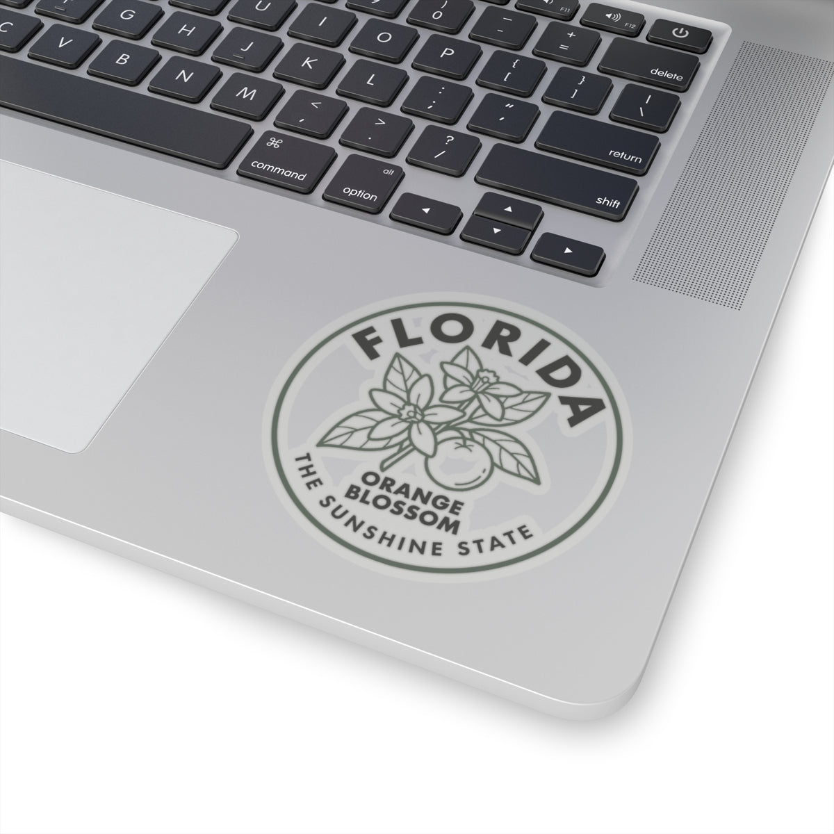 Transparent vinyl sticker on laptop lid, Florida orange blossom emblem in a circle