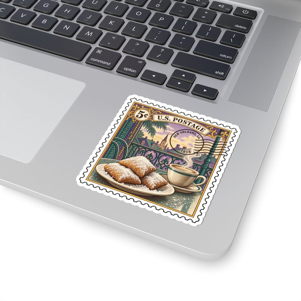 Kiss-cut vinyl sticker placed on a laptop keyboard, vintage stamp with beignets and coffee