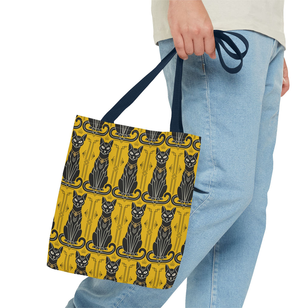Yellow tote bag held at side with black cat pattern and navy strap
