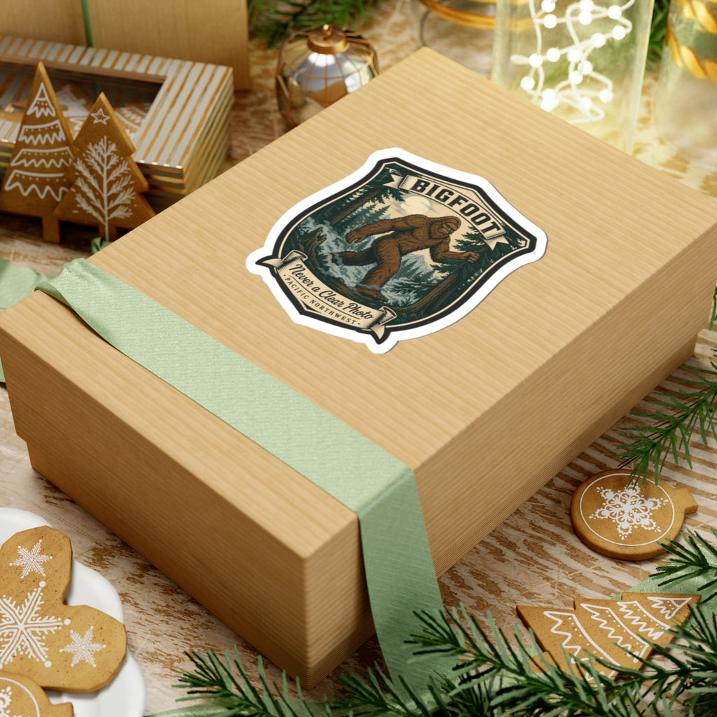 Bigfoot hiking badge sticker on gift box with evergreen forest shield artwork