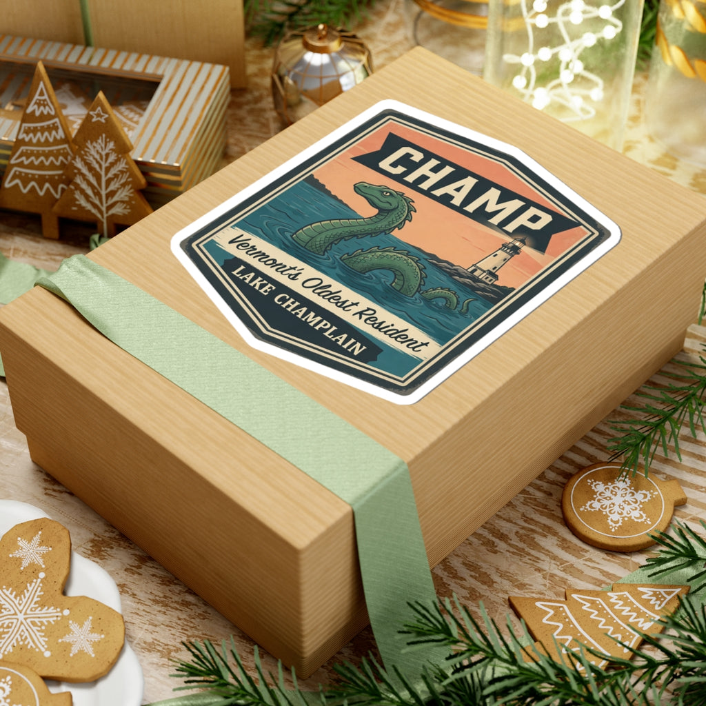 CHAMP vintage sticker on a wrapped gift box, featuring green sea serpent and lighthouse