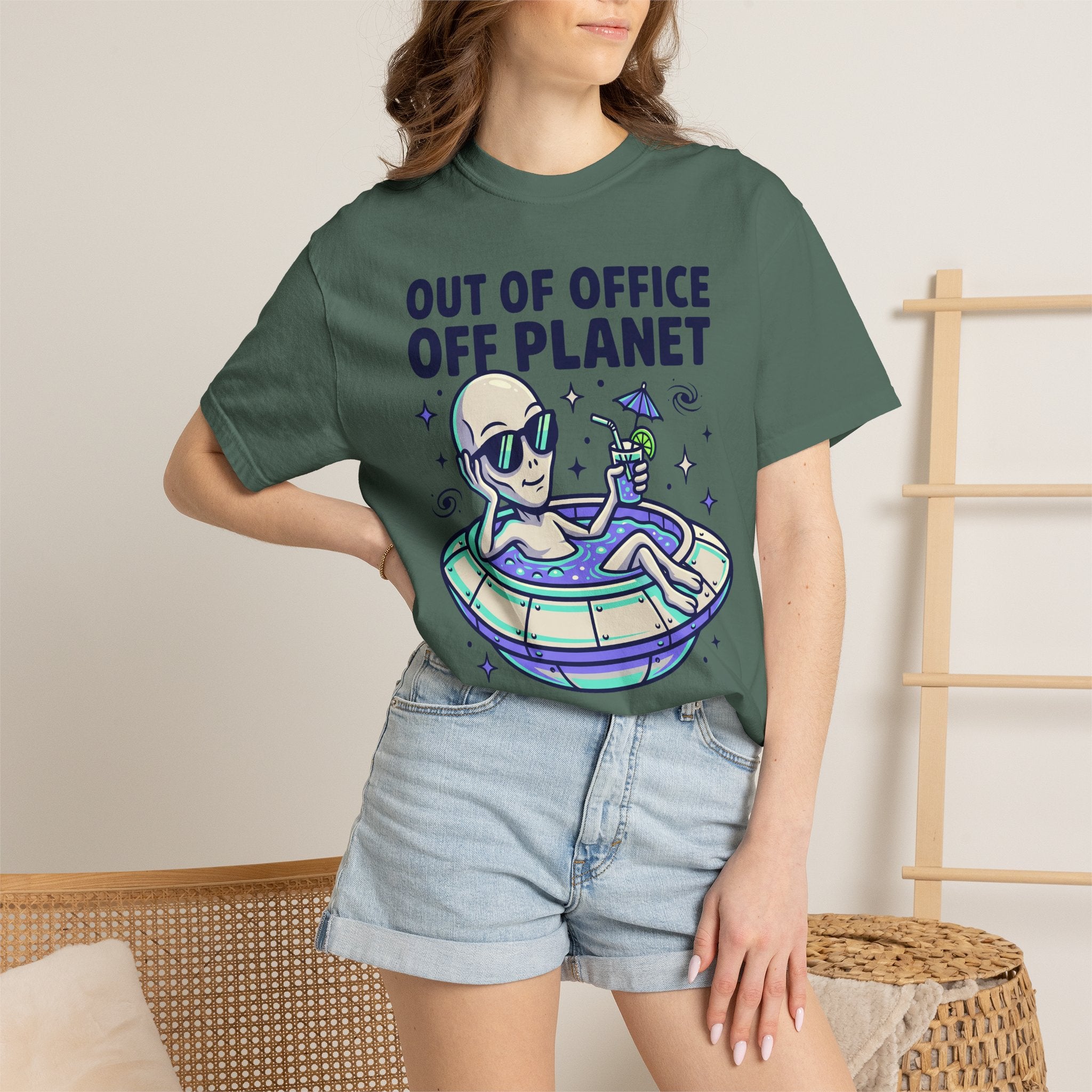 Green T-shirt worn by model with “Out of Office Off Planet” alien floatie graphic