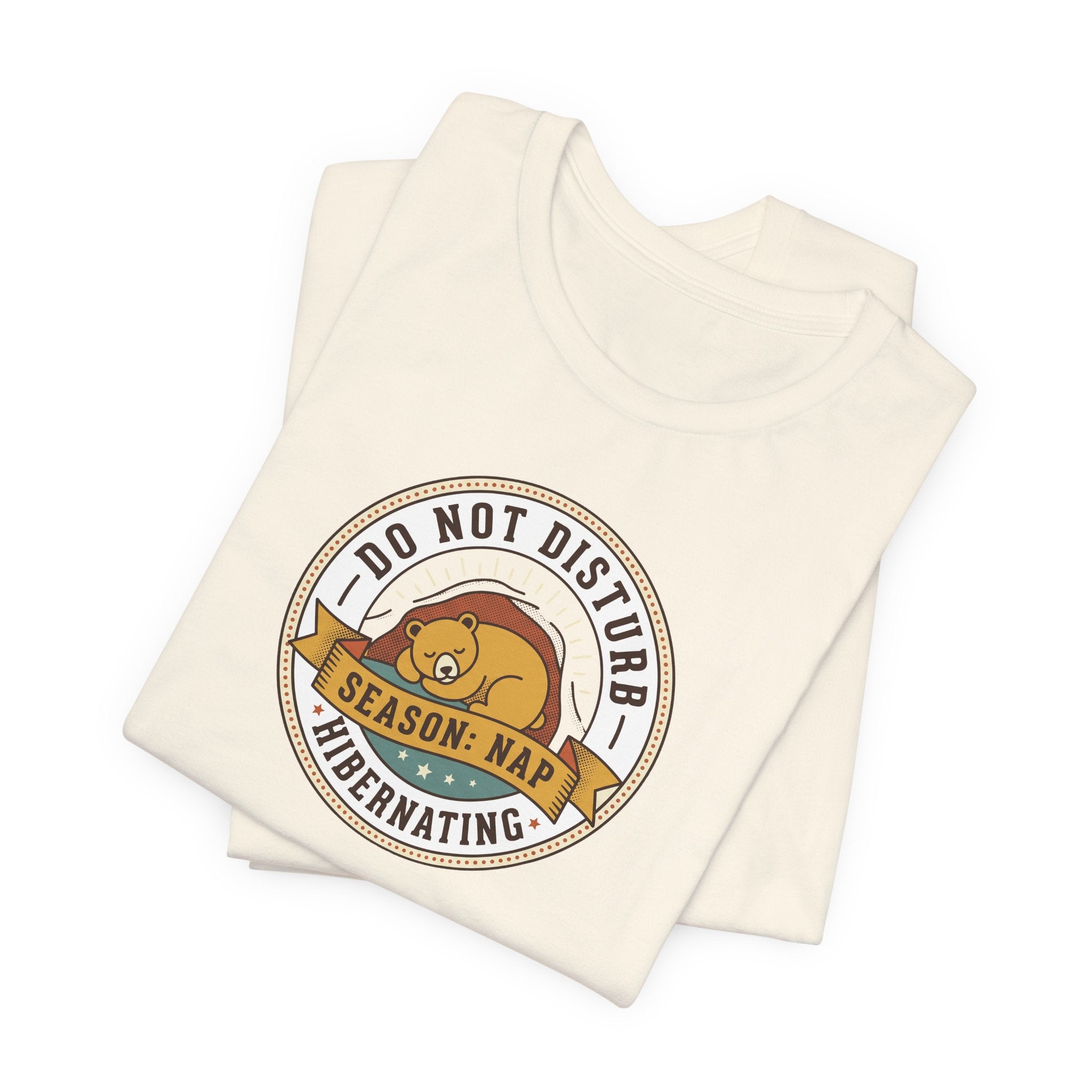 Cream T-shirt with round bear sleeping badge graphic on chest
