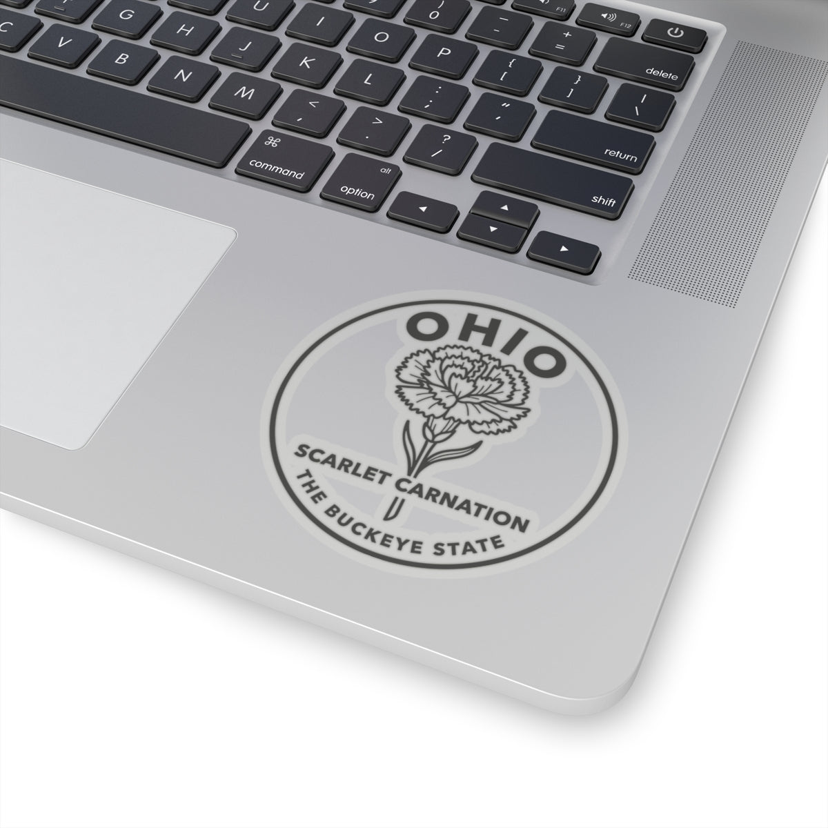 Round Ohio state flower decal on laptop lid near keyboard