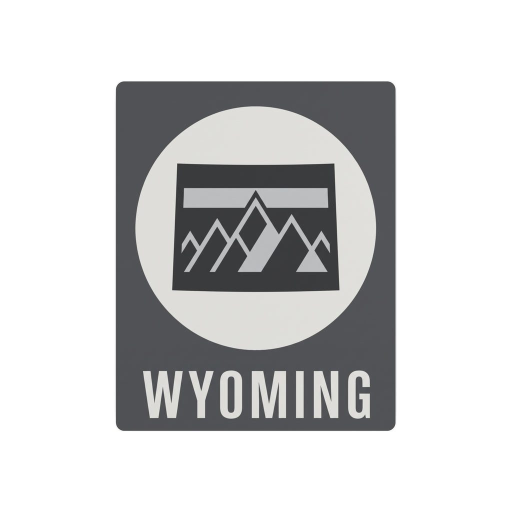 Wyoming metal wall sign with dark gray background, white circle, mountain graphic, and WYOMING text