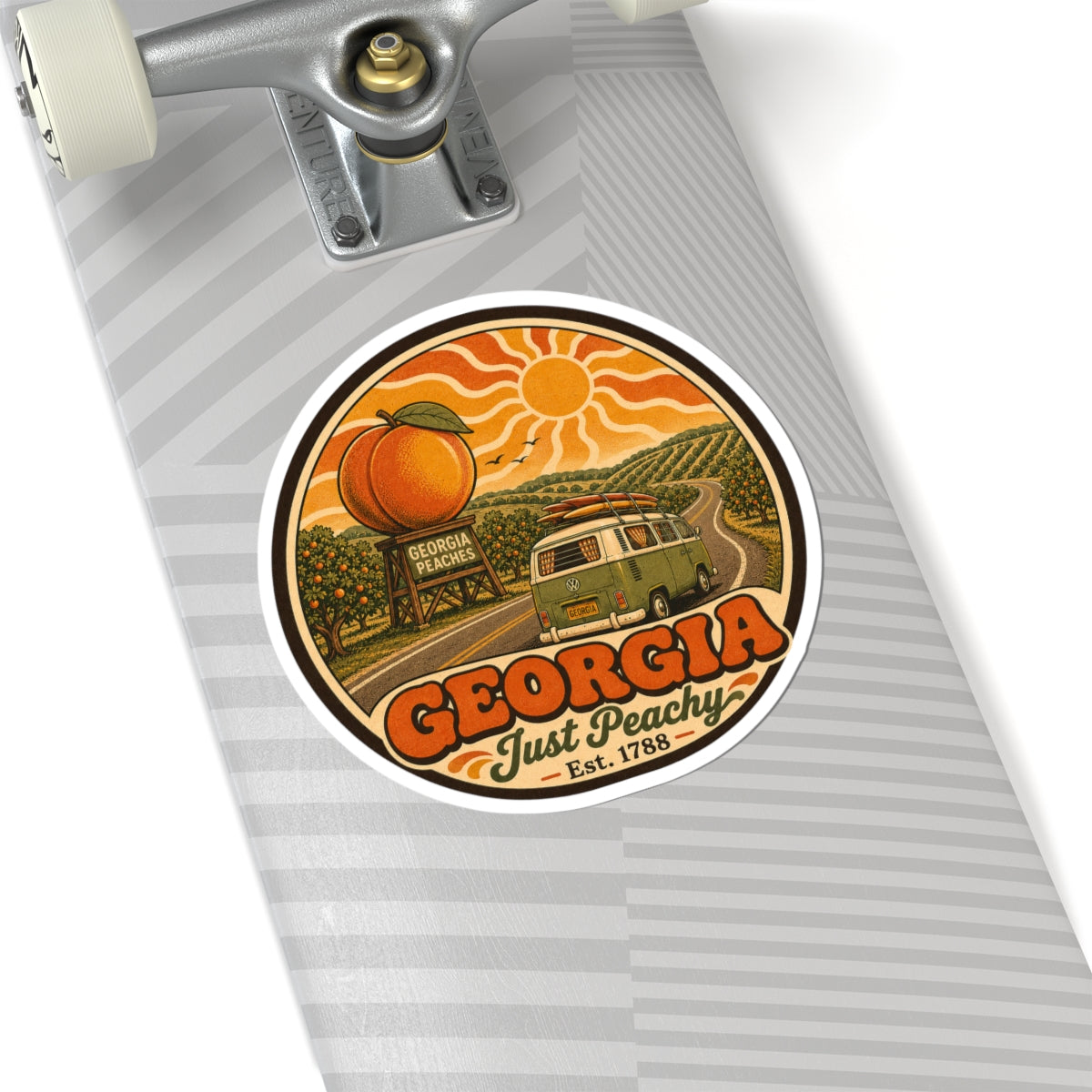 Round vinyl sticker on gray skateboard deck, featuring Georgia Just Peachy and green van