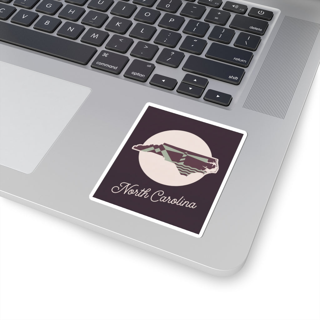 North Carolina kiss-cut decal sticker on laptop, purple state silhouette with “North Carolina”
