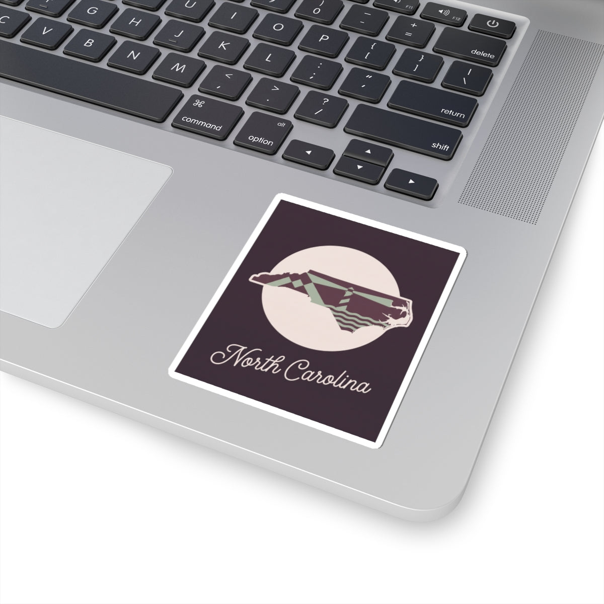 North Carolina kiss-cut decal sticker on laptop, purple state silhouette with “North Carolina”
