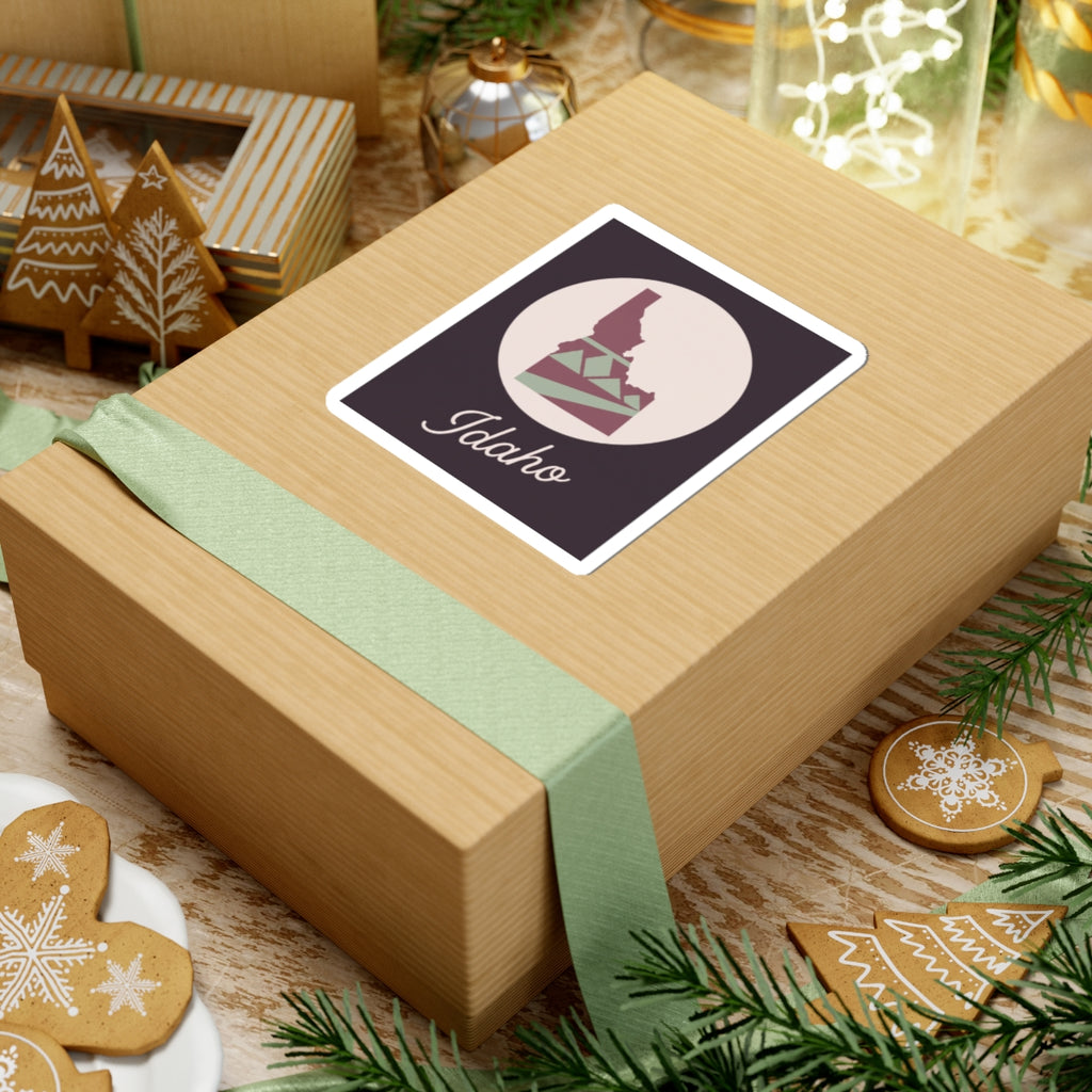 Idaho state silhouette vinyl decal on wrapped gift, mauve square with cursive 'Idaho'