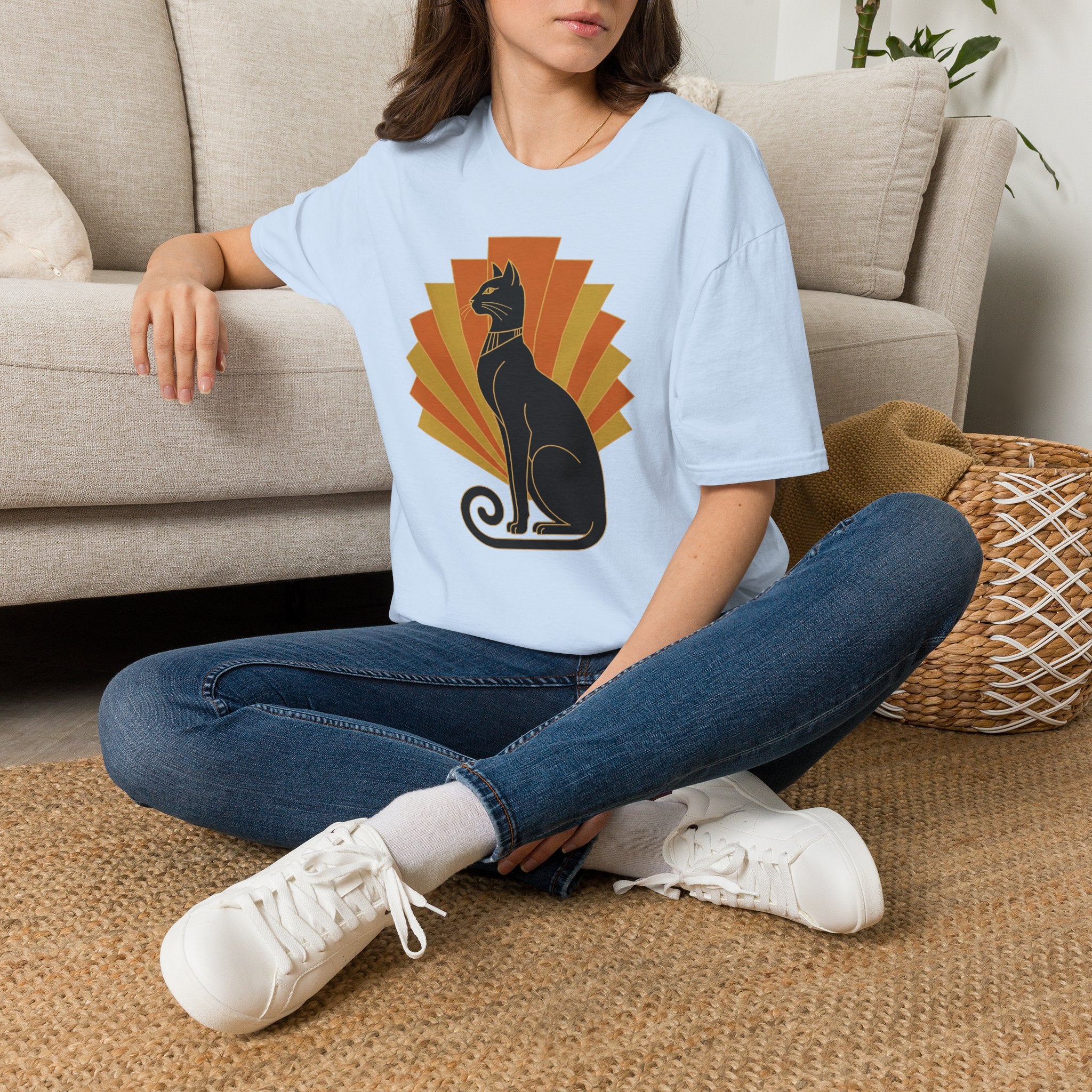 Light blue T-shirt with crew neck and short sleeves, black cat graphic in orange sunburst
