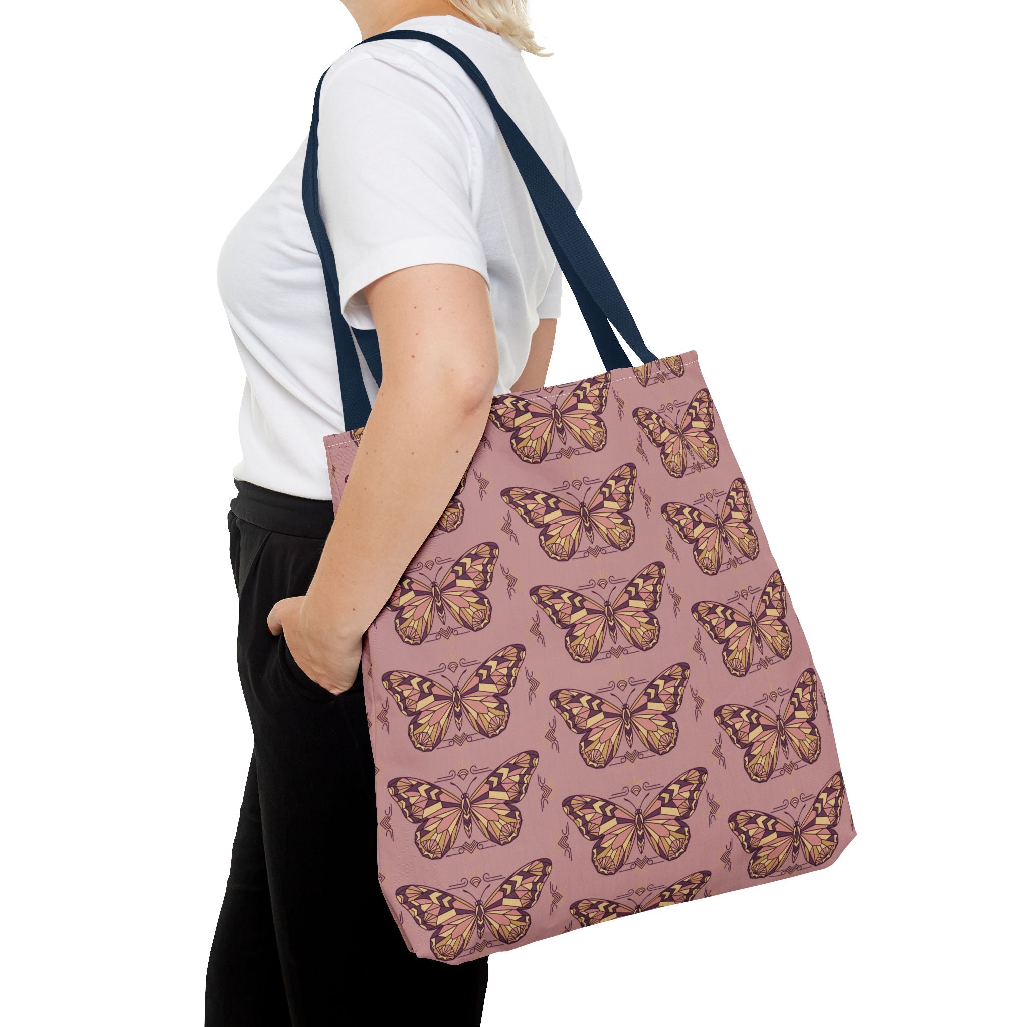 Butterfly print tote bag with dark handle straps, carried by a person