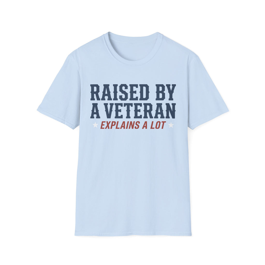 Light blue crewneck T-shirt with 'RAISED BY A VETERAN' and 'EXPLAINS A LOT' graphic