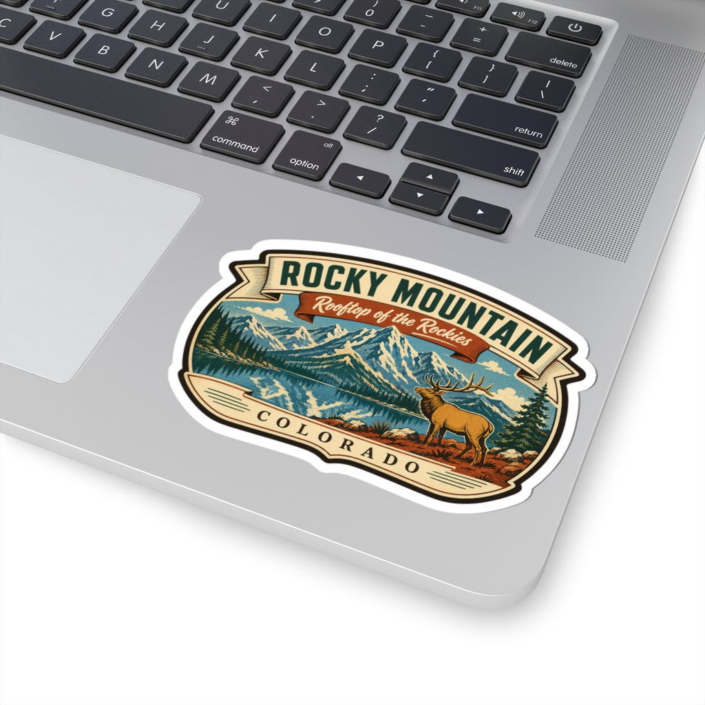 Travel sticker on a laptop lid, showing mountain lake landscape, elk, and Rocky Mountain Colorado