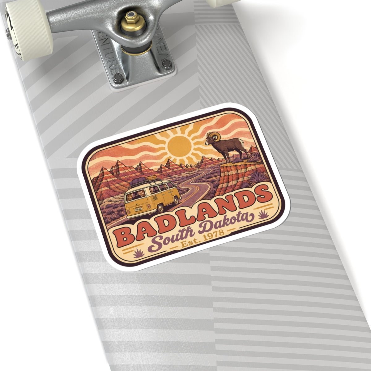 Kiss-cut sticker on a skateboard deck: desert road camper van, bighorn sheep, Badlands