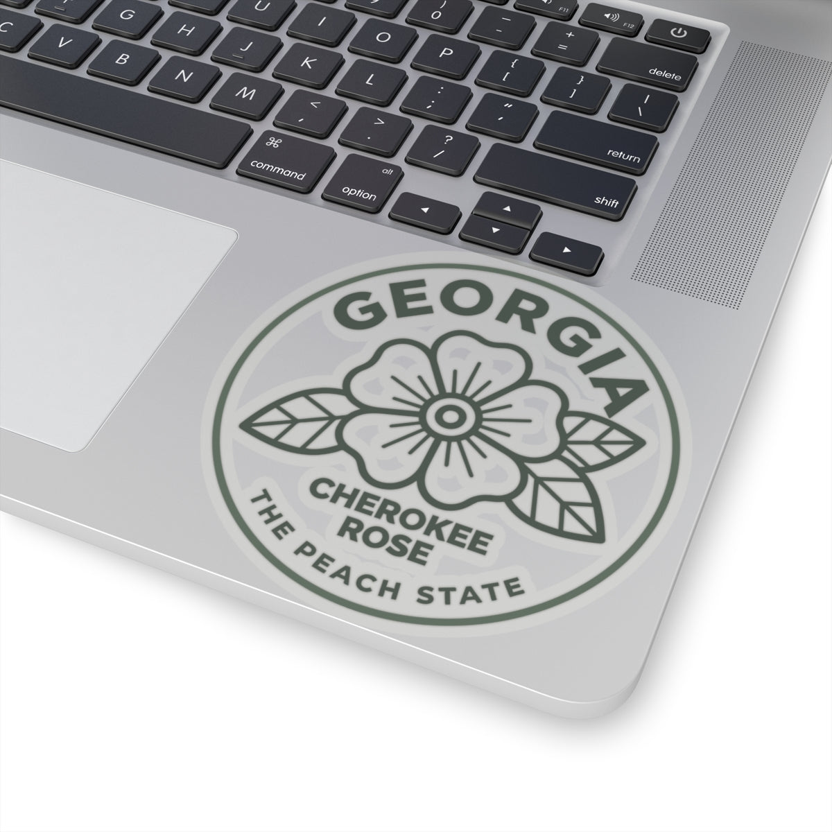 Transparent vinyl round decal showing Georgia, Cherokee Rose, and The Peach State on laptop