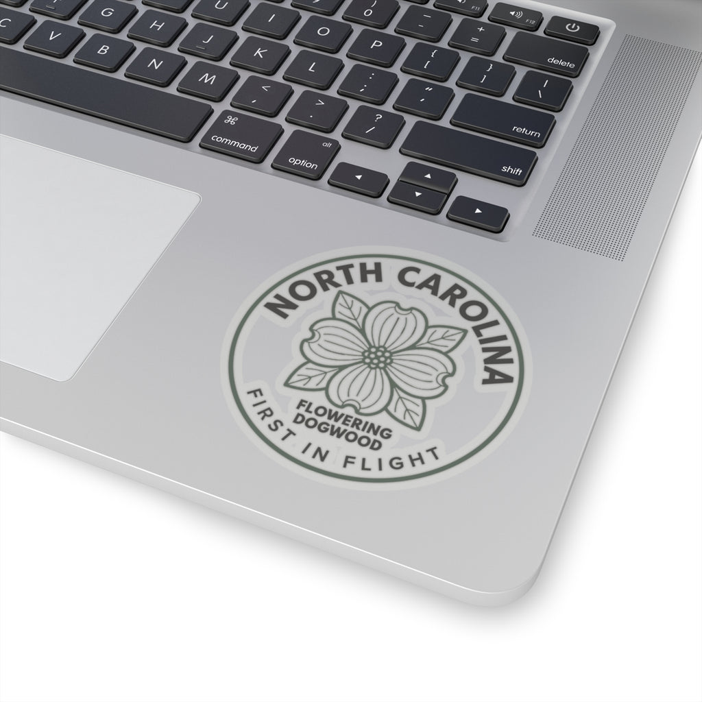 Transparent vinyl decal on laptop lid, gray dogwood flower with NORTH CAROLINA ring