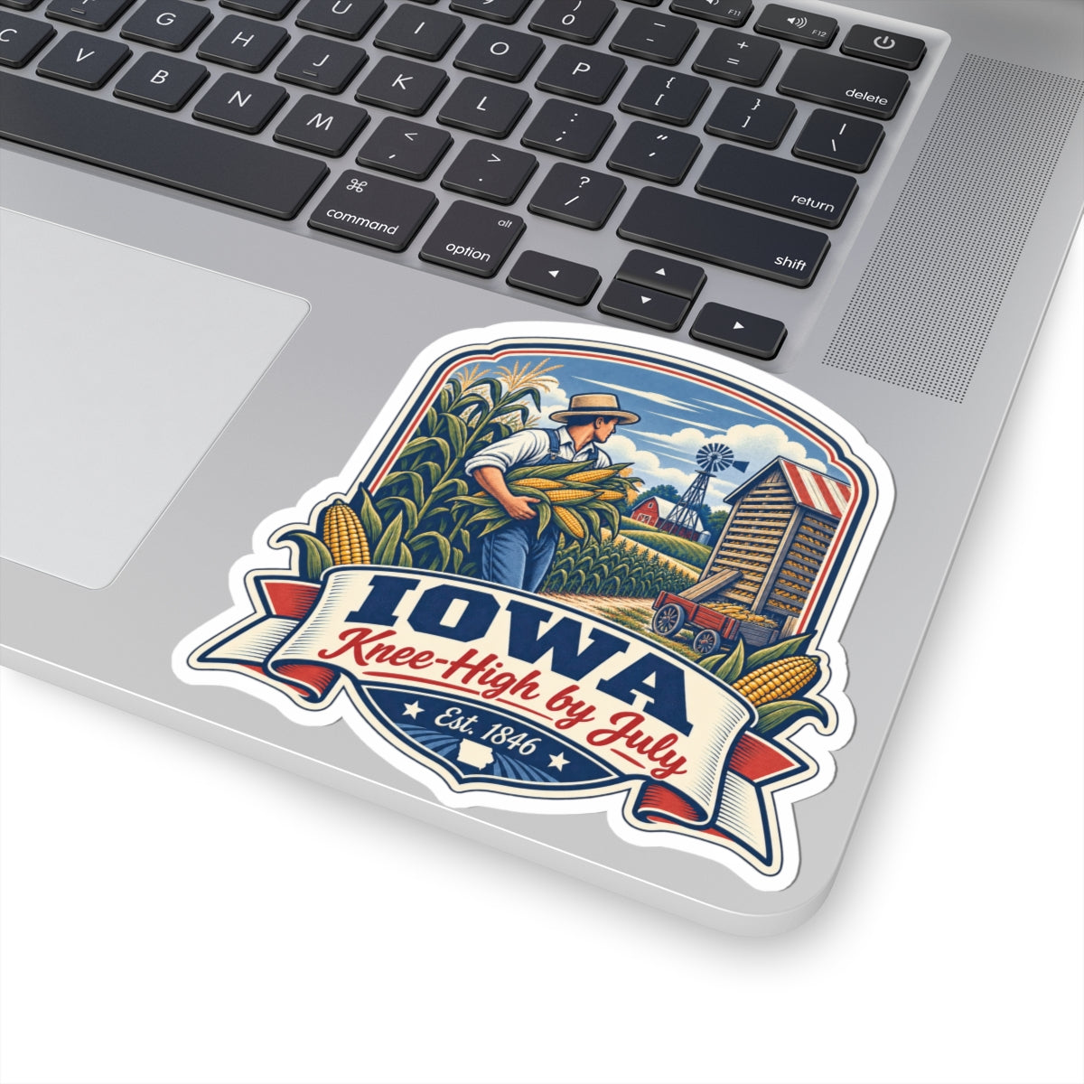 Iowa Knee-High by July sticker decal on laptop featuring farmer holding corn and windmill
