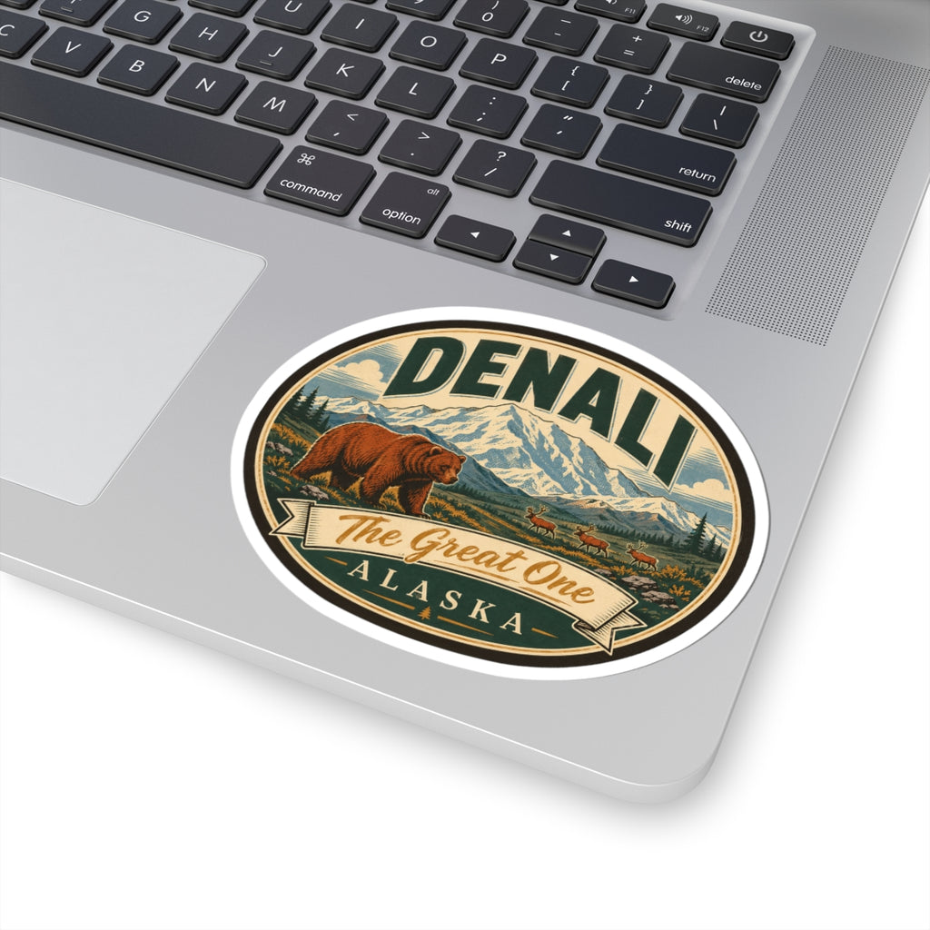 Denali oval sticker on laptop lid with bear, mountains, and “The Great One Alaska” banner