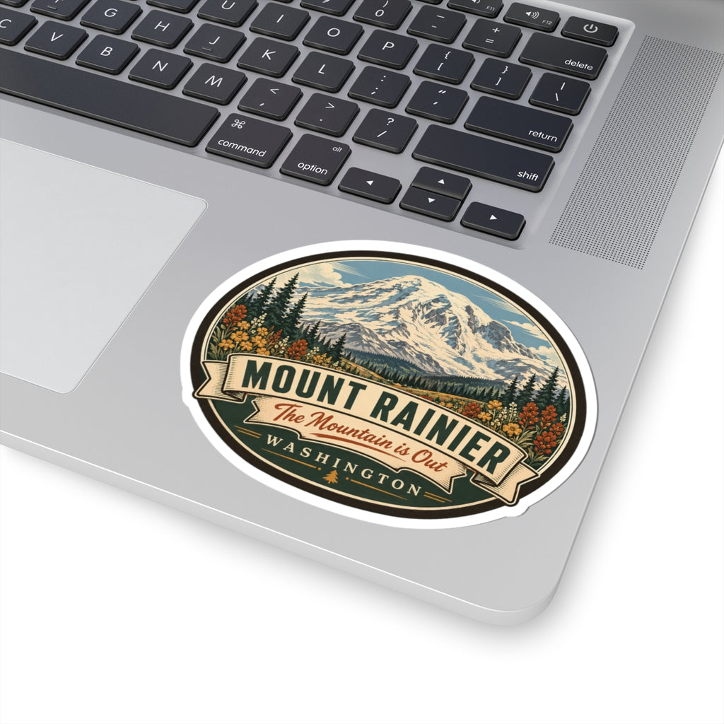 Oval Mount Rainier travel sticker on laptop lid with mountain peak and WASHINGTON banner
