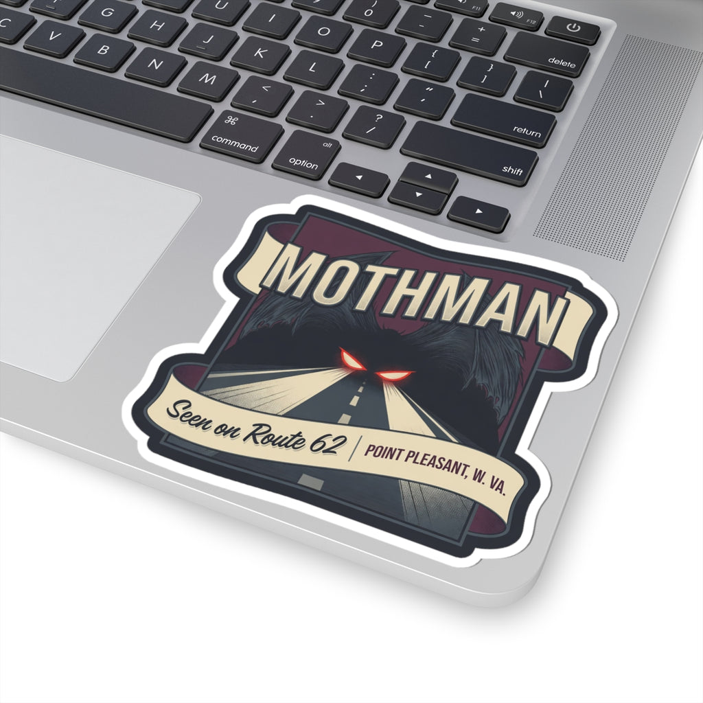 Mothman decal on laptop: road illustration with red glowing eyes, “Seen on Route 62,” and W.Va.