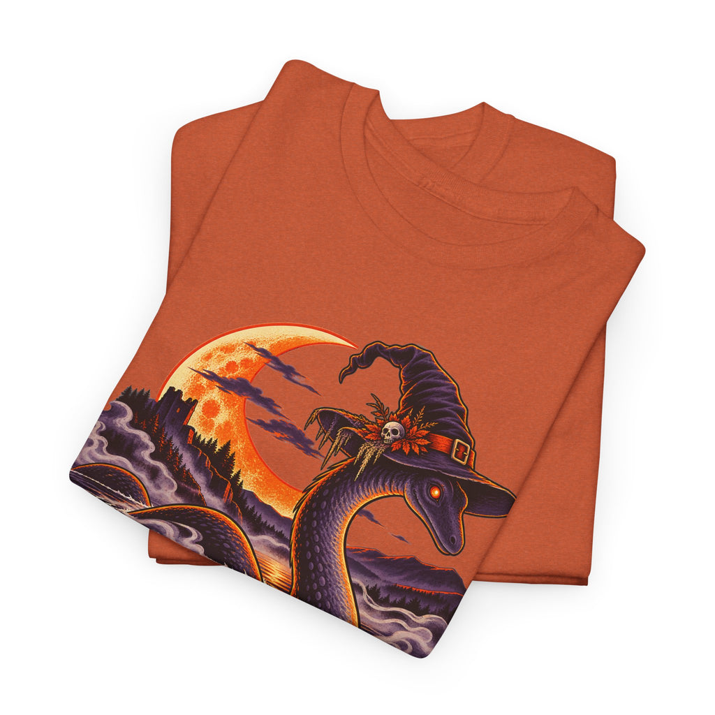 Orange t-shirt with Nessie in witch hat and moonlit lake graphic, folded view