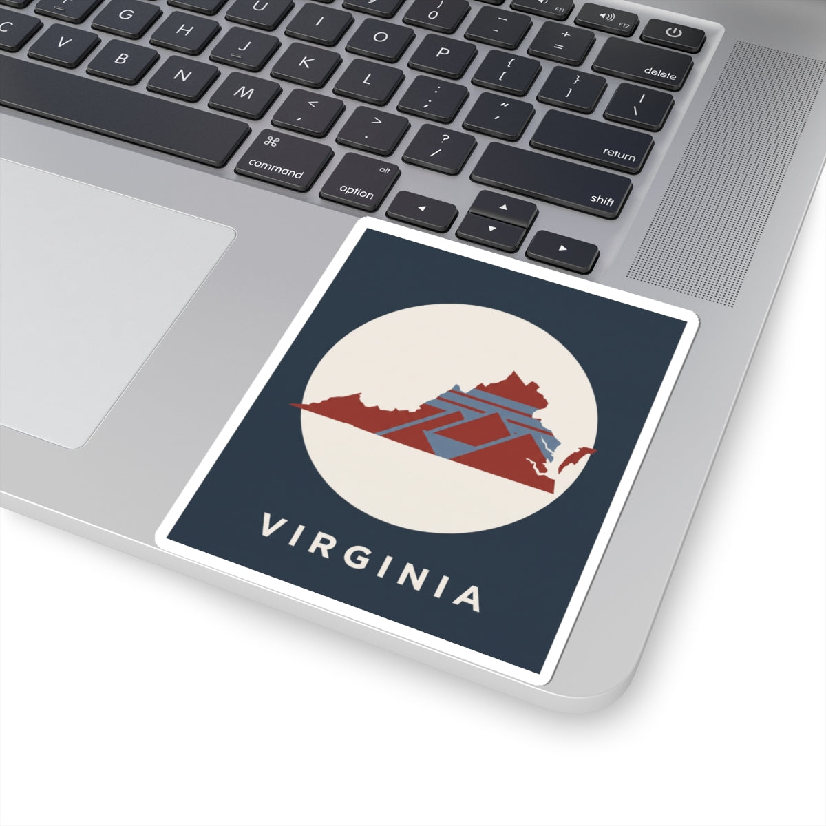 Virginia map decal on laptop: dark blue square, cream circle, red geometric Virginia artwork