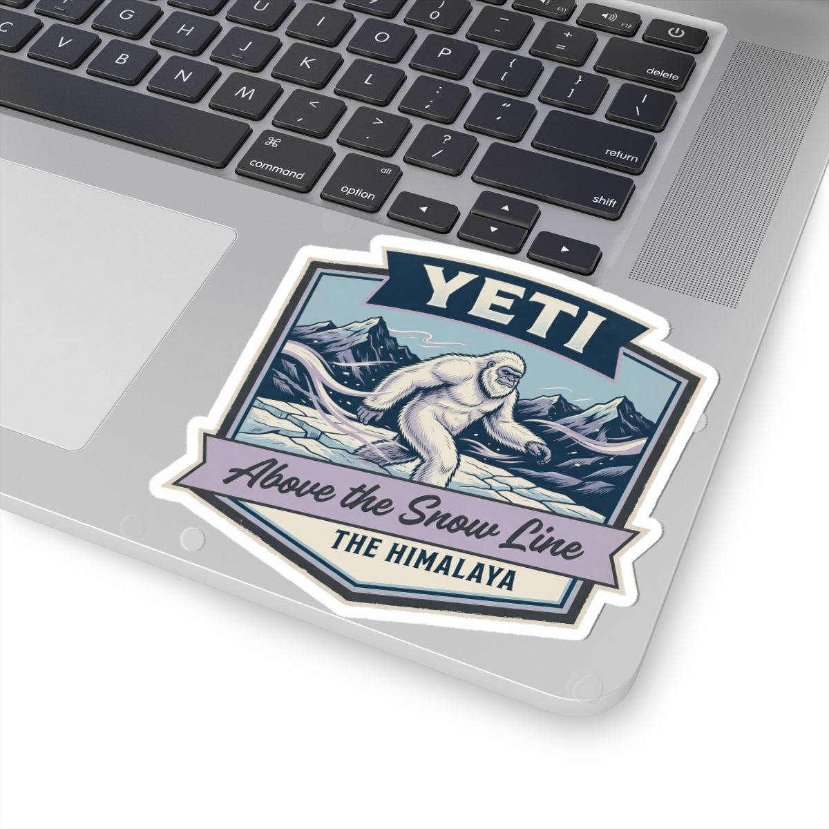 YETI die-cut sticker on laptop showing Himalayan sasquatch above the snow line