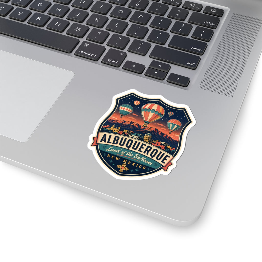 Luggage tag sticker on a laptop: Albuquerque badge with hot air balloons and mountains