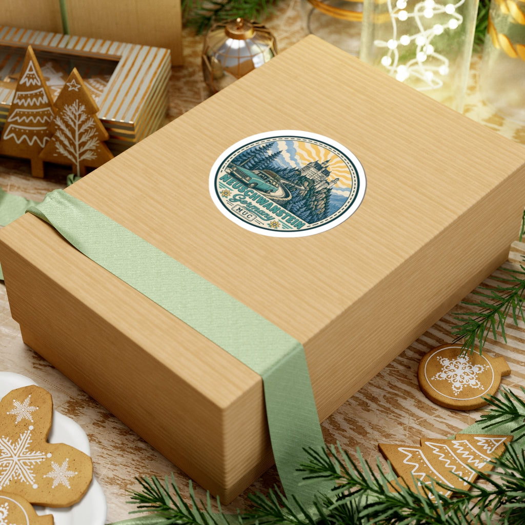 Circular kiss-cut sticker on a wrapped gift box: Neuschwanstein Castle, pine trees, vintage car, “MUC”.