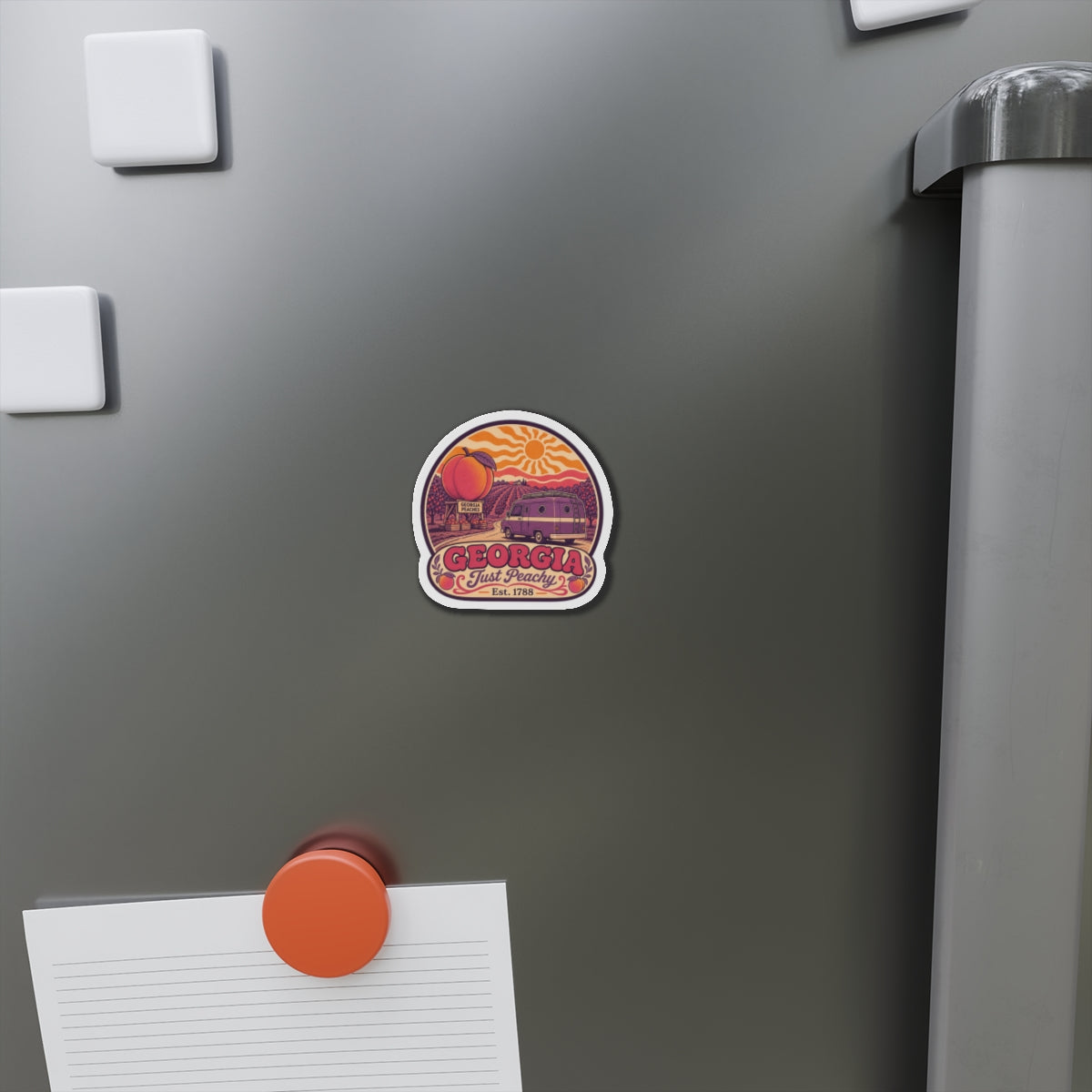 Die-cut Georgia Just Peachy magnet attached to a stainless refrigerator door