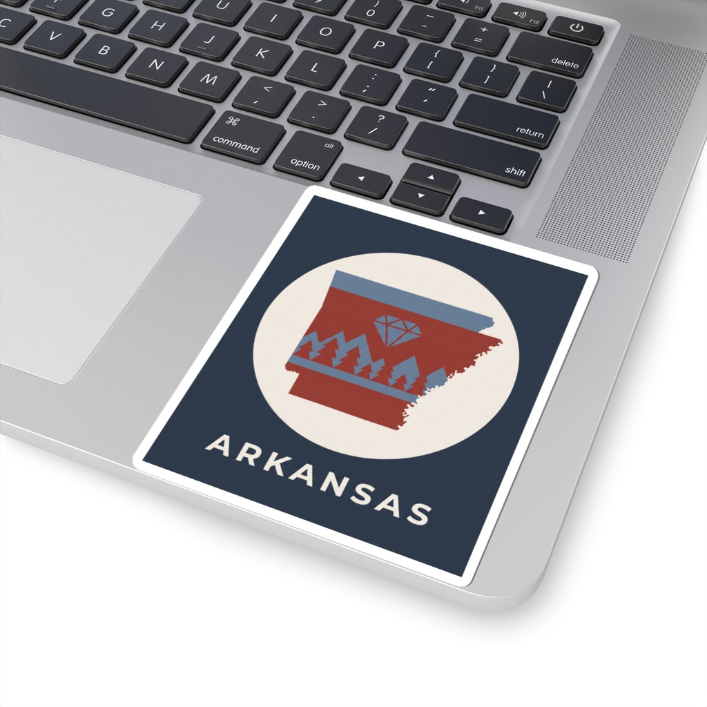 Arkansas emblem sticker on laptop keyboard, blue/red map with diamond and pine trees