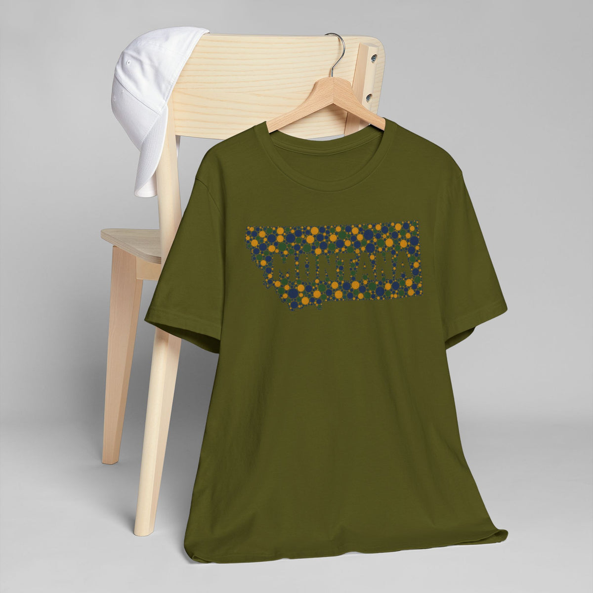 Olive green T-shirt with colorful dotted Montana outline graphic on chest.