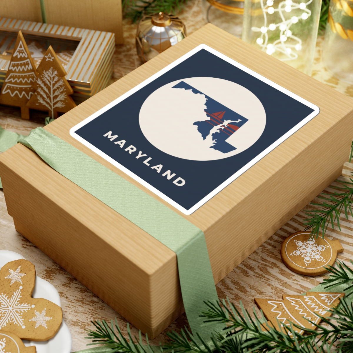 Maryland sticker on a wrapped present, navy square badge with circular map and sailboat