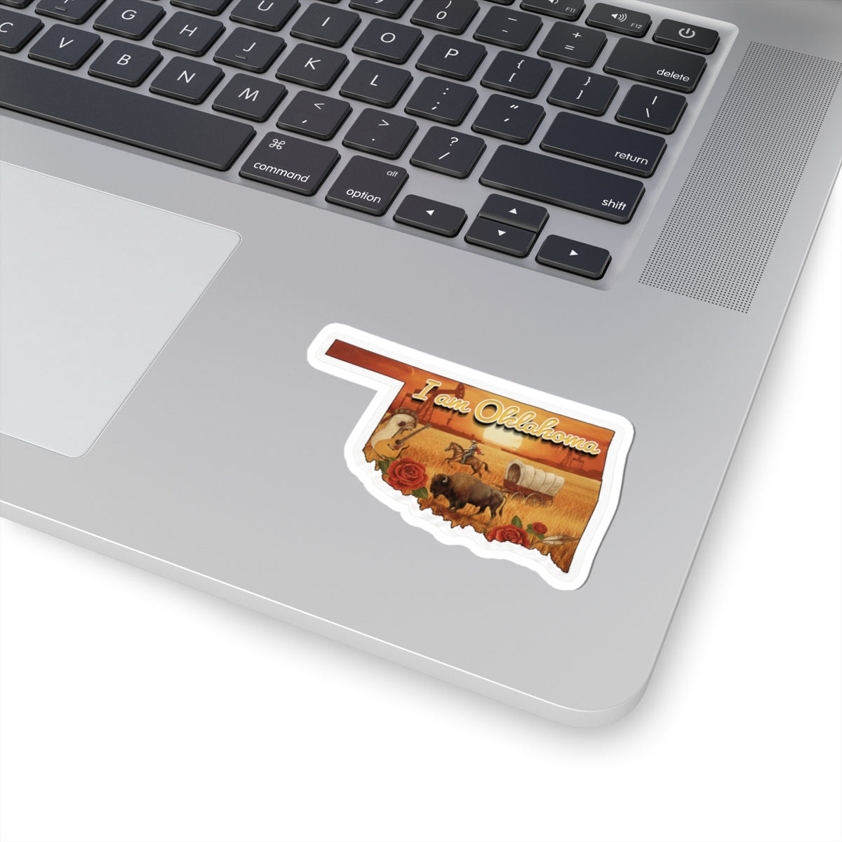 I am Oklahoma die-cut sticker on laptop, desert scene with roses, buffalo and wagon