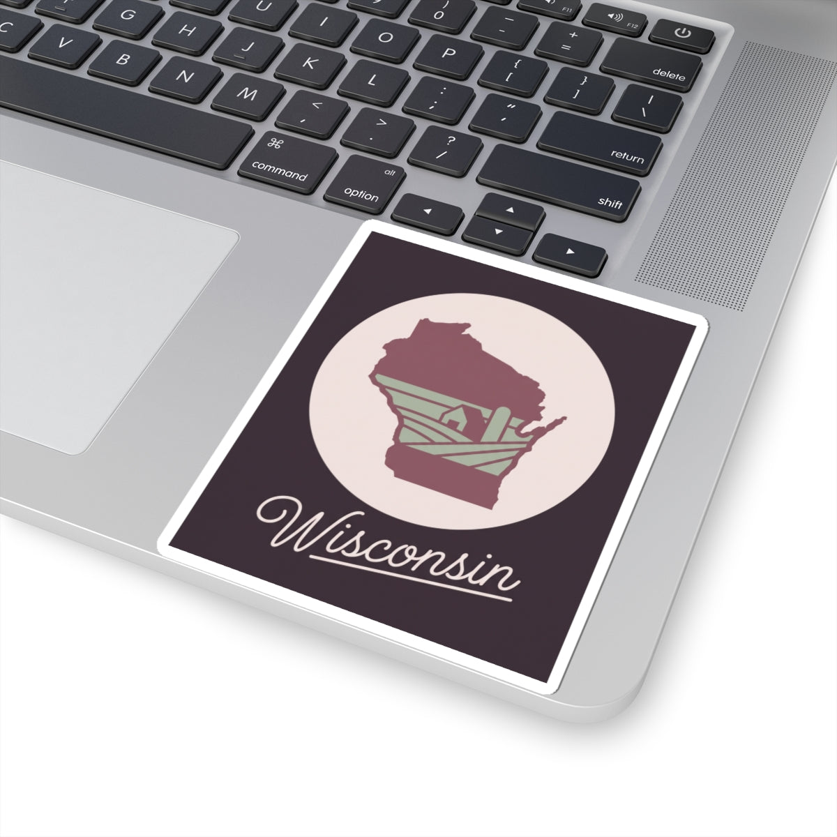 Wisconsin kiss-cut sticker on laptop: maroon state silhouette and cursive “Wisconsin”
