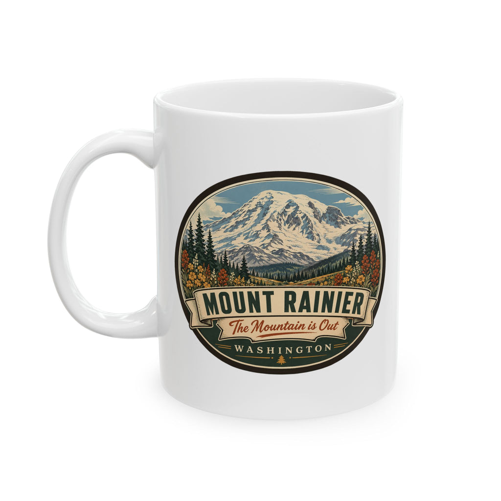 White ceramic mug with Mount Rainier landscape emblem and text badge, front view